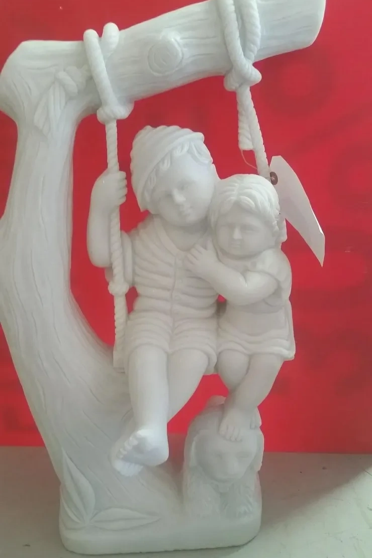 White statue of two children on swing