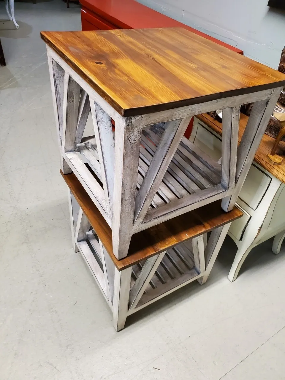 Stacked wooden tables with slatted shelves.