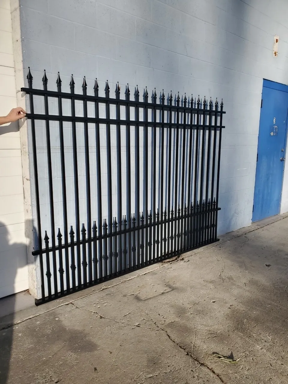Black metal fence leaning against a wall.