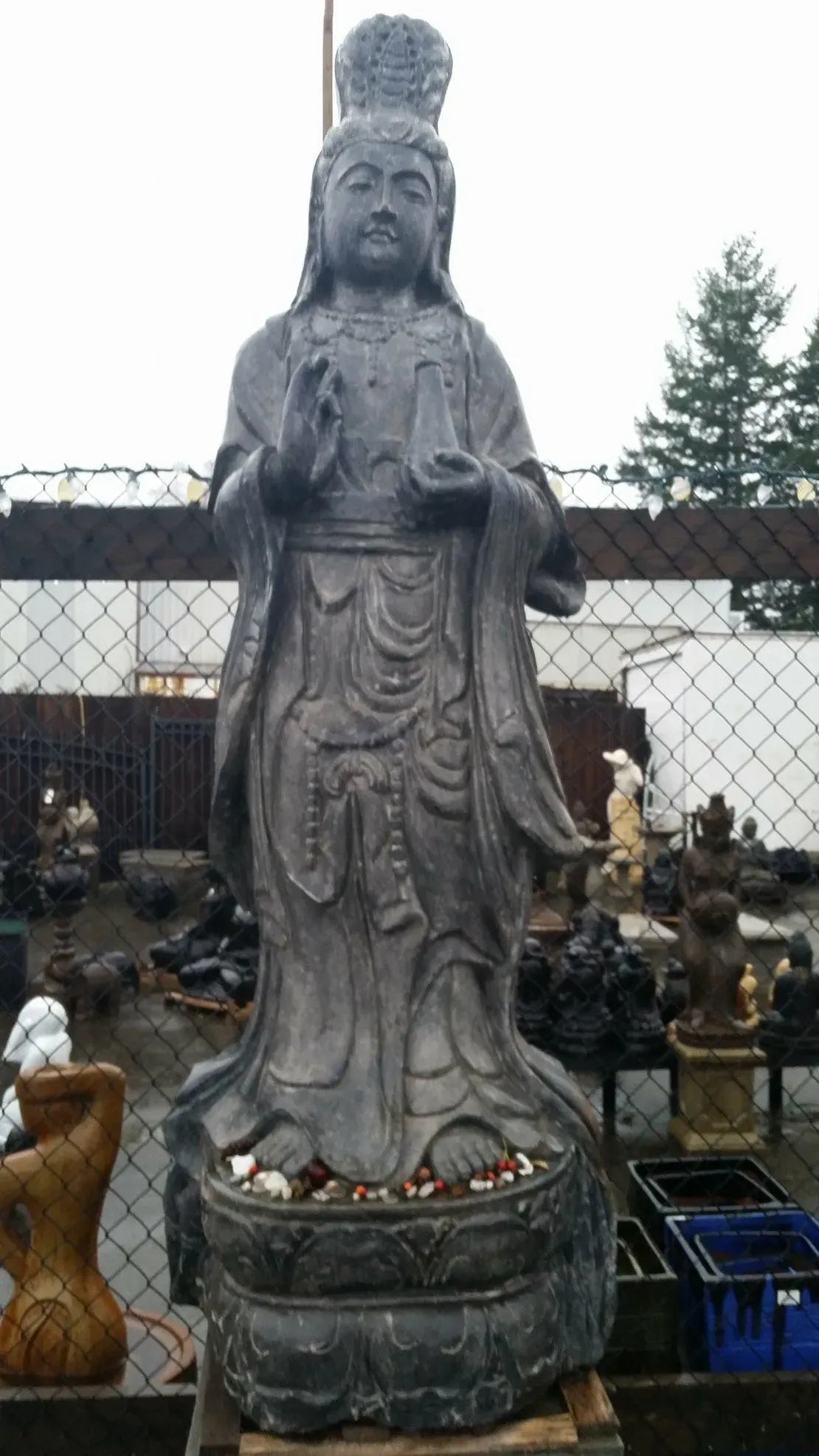 Stone statue of a robed figure outdoors.
