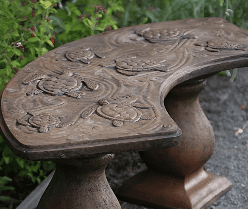 Curved bench with carved turtle design.