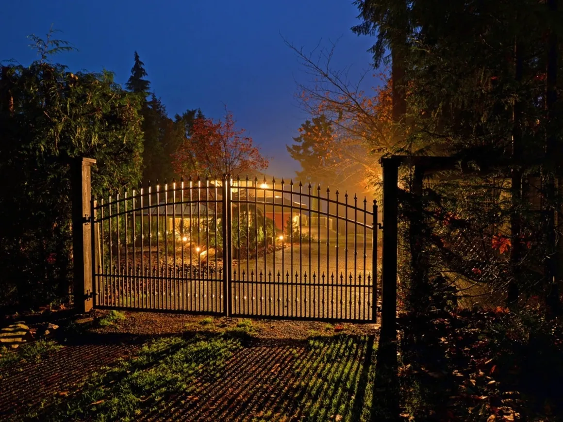 Illuminated gate at night in autumn setting.