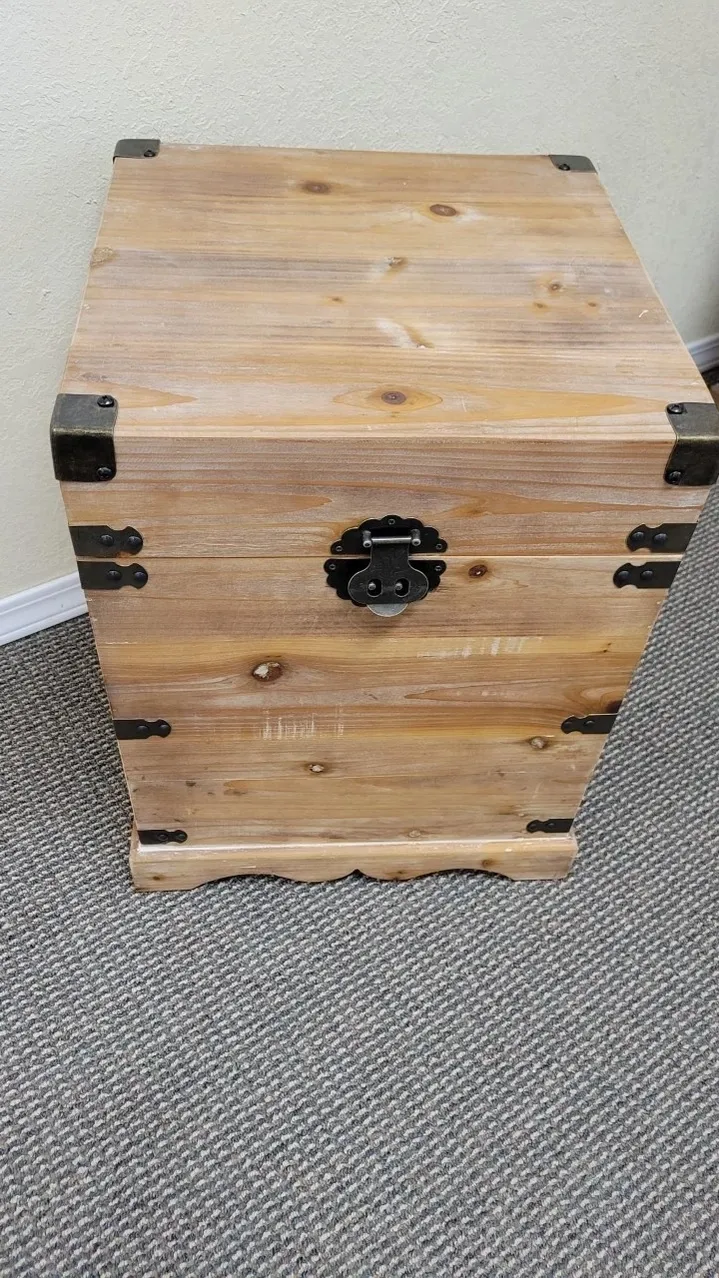 Wooden chest with black metal hinges.
