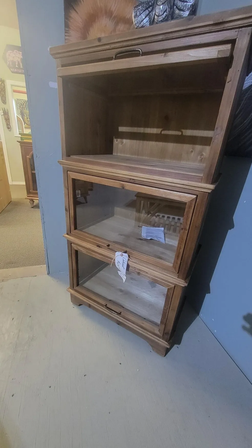 Wooden glass-front cabinet with three shelves.