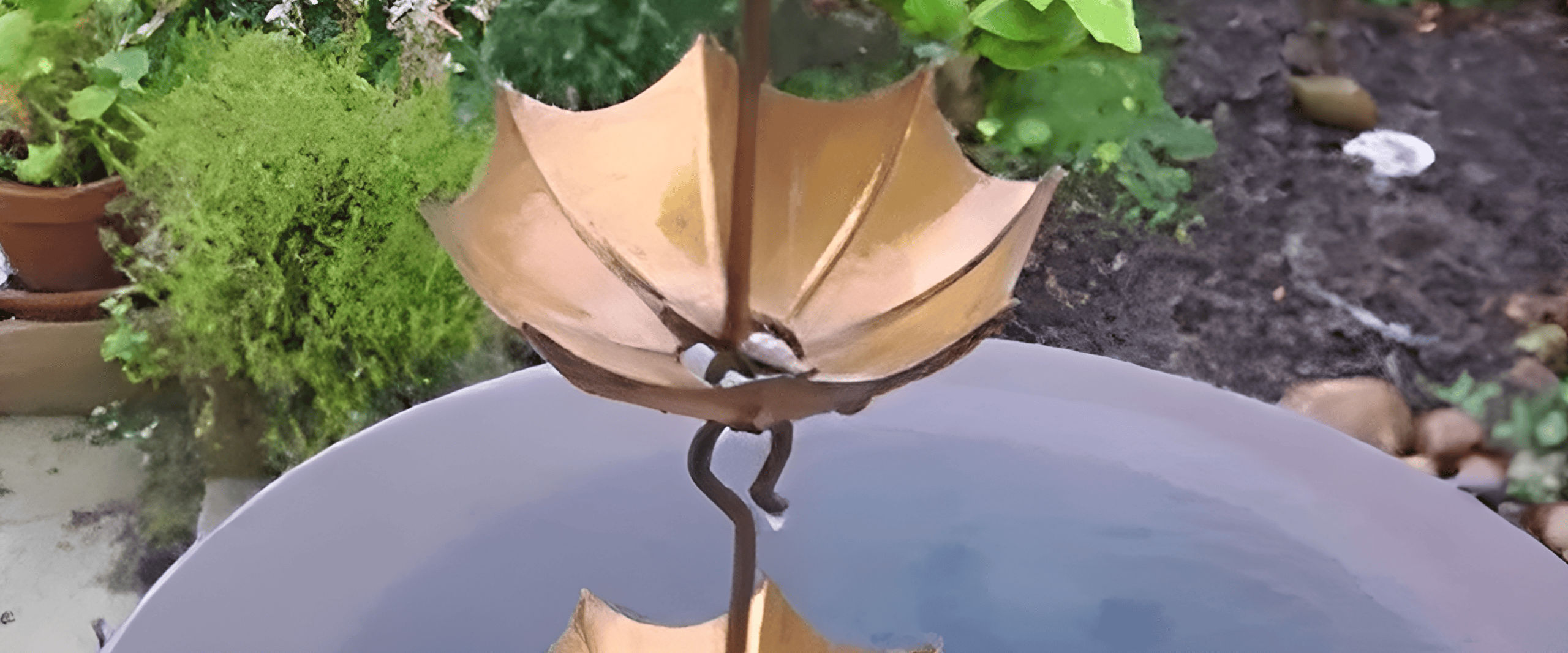 Copper umbrella-shaped garden fountain in basin